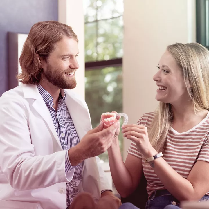 Zahnarzt und Patientin mit Alignern