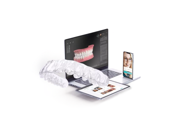Clear aligners, laptop and mobile phone. 