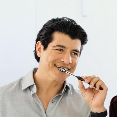 En man som borstar tänderna