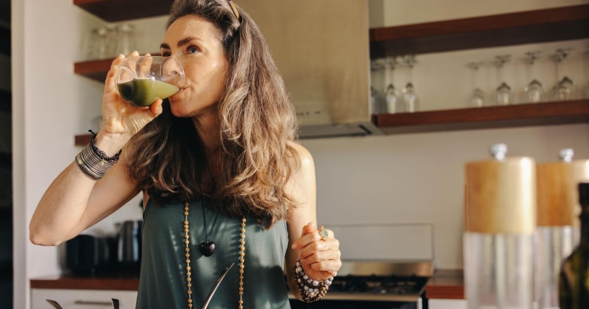 a woman making a healthy smoothie after getting dental implants