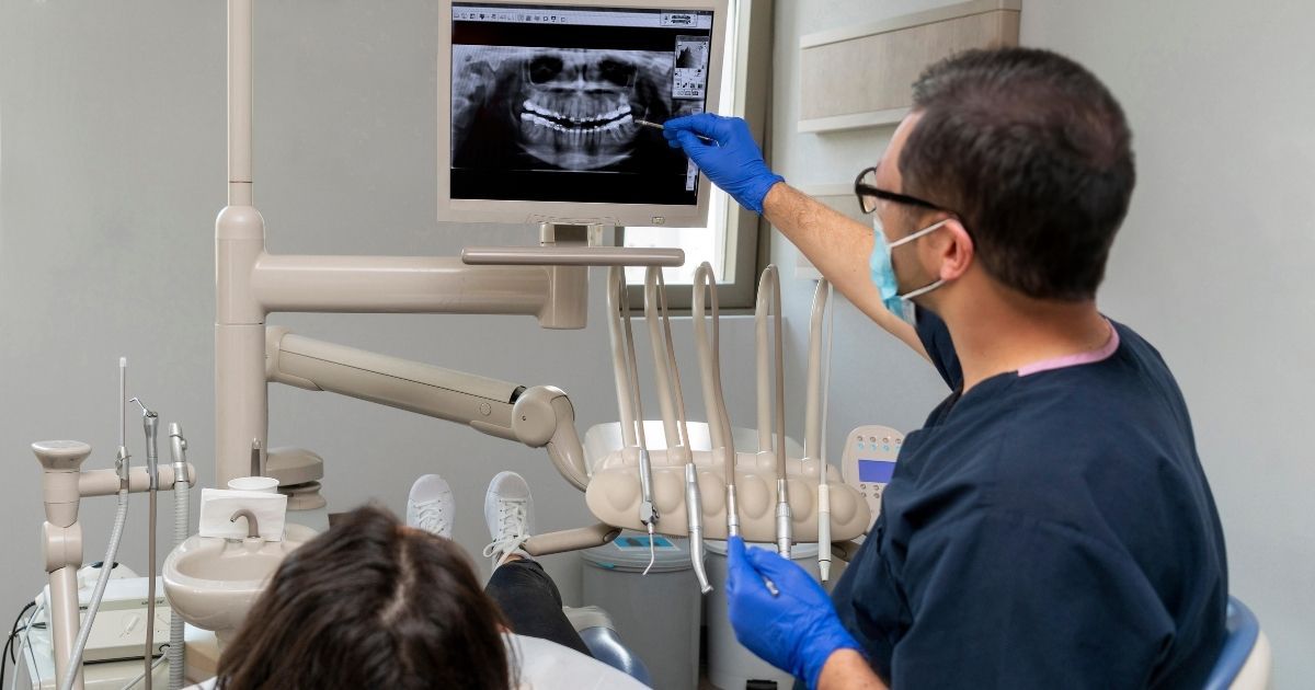 Dentist holding up an xray of a dental implant patient to check bone volume for bone augmentation