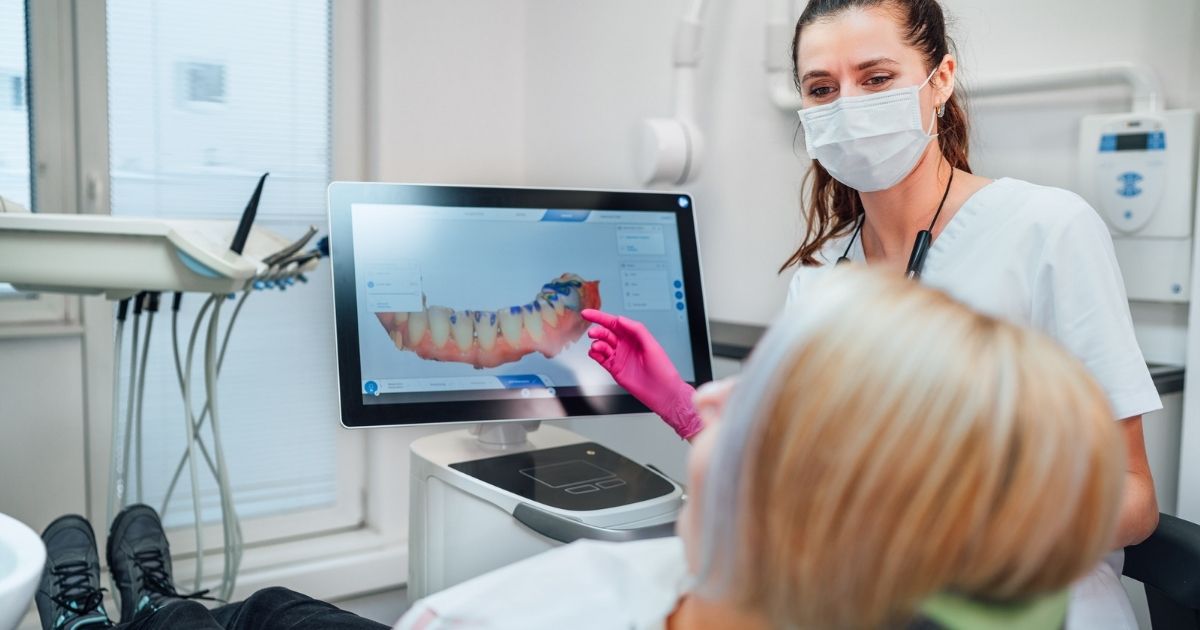 Dental implant dentist showing the patient a projection of the teeth