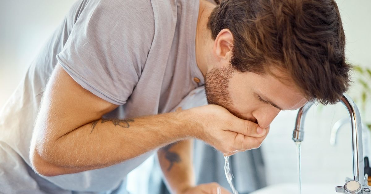 a man rinsing his mouth after brushing the teeth