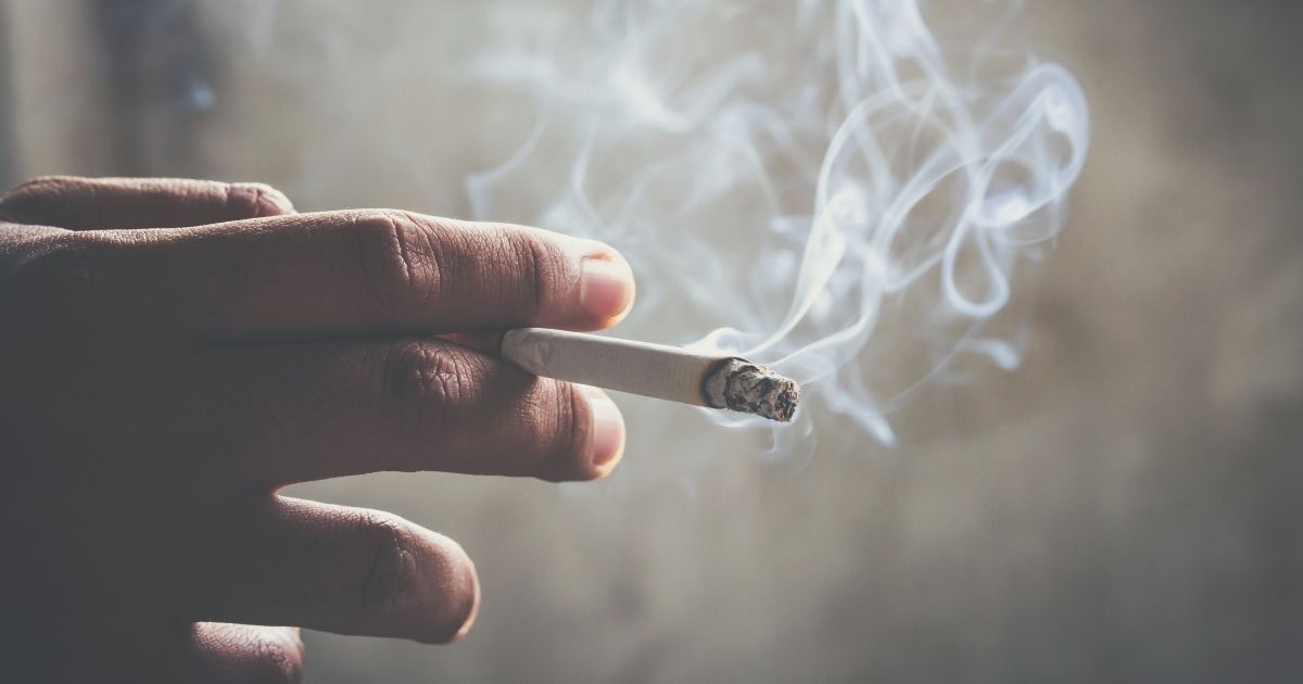 A smoker with a cigarette before a dental implant procedure