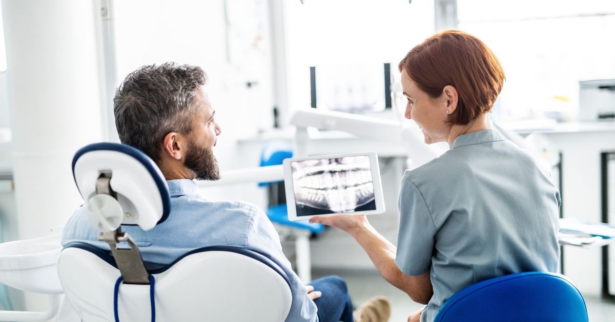 dentist showing a full mouth dental implant patient an xray